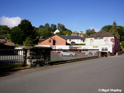 Looking along a road with a bridge rail alongside it