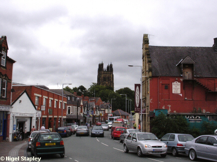 Picture of a street with a church tower in the background