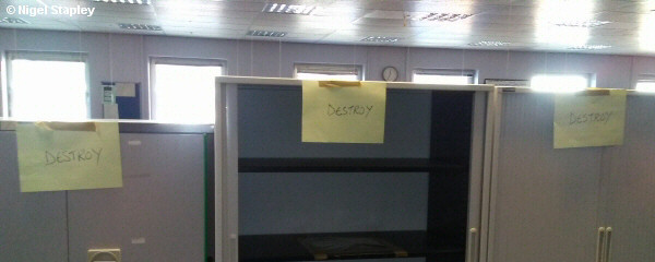 Photo of office cupboards with post-its on them saying 'DESTROY'