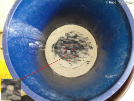 Photo of cleanser residue on the bottom of a plastic bucket which makes a pattern looking like Lenin