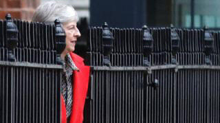 Photo of Theresa May which looks like she's part of the railings outside 10 Downing Street