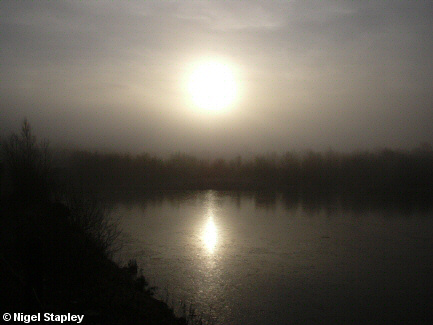 Photograph of low sun over a frozen lake