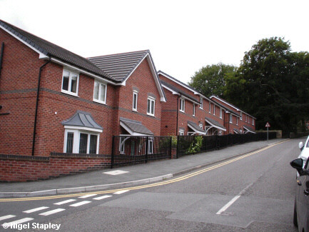 Photo of a row of new houses along the side of a road