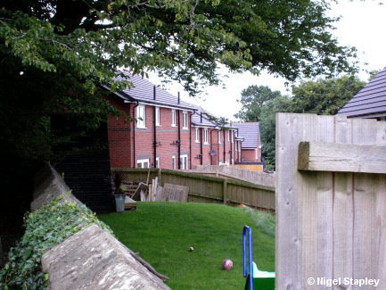 Photo of some new houses taken over a stone wall